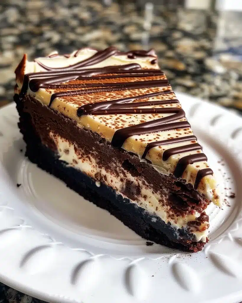 Brownie-crust mini cheesecakes displayed on a platter, topped with chocolate sauce.