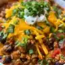Bowl of hearty turkey chili garnished with herbs and spices.