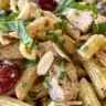 Waldorf-style chicken pasta salad with apples and nuts in a bowl