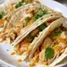 Mouthwatering white chicken enchiladas topped with creamy sauce and cheese