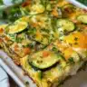 Delicious zucchini frittata served on a plate, garnished with herbs.